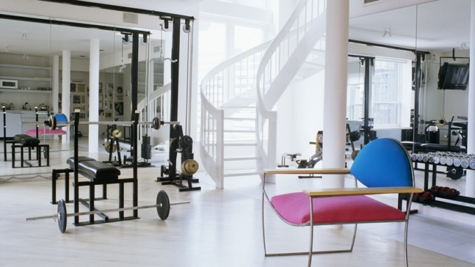 Modern chair with colourful upholstery and free-standing staircase in home gym